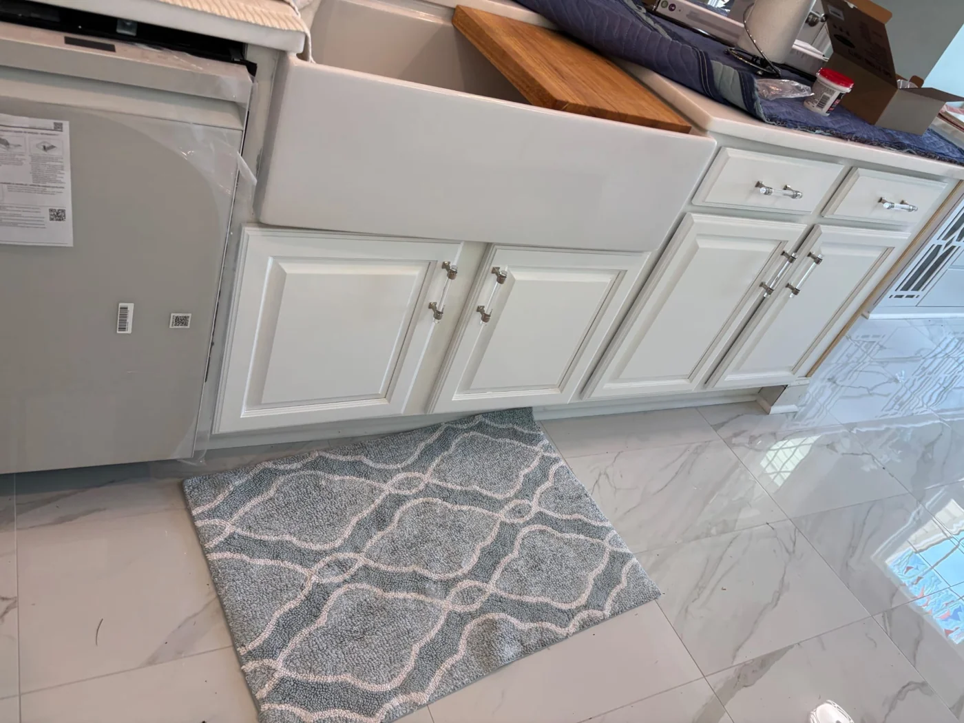 White cabinet fronts beside a protected work area.