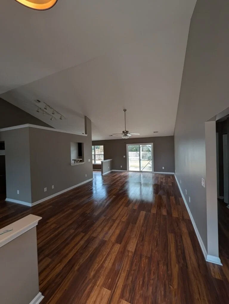 An open floor plan, warm wood tones and contrasting white trim.