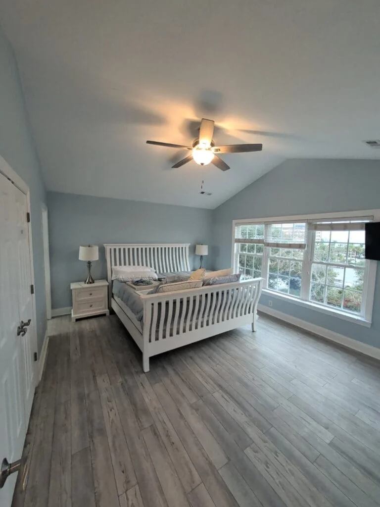 Cool wall tones frame the bed and window light.